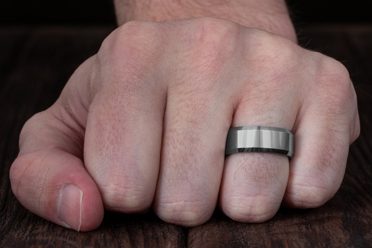 The Savant, silver tungsten mens wedding band or anniversary ring close up on hand.