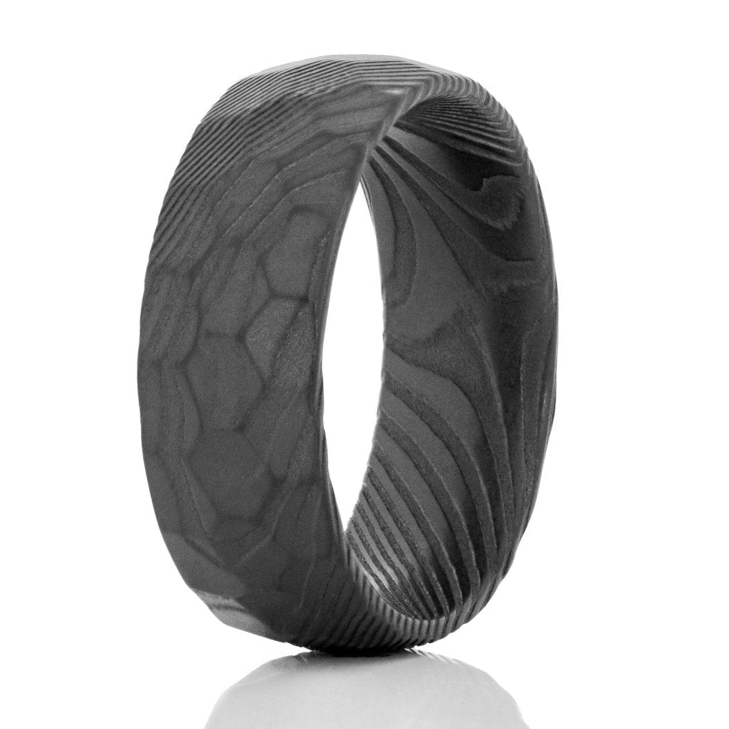 The Rory, a 8mm black Damascus steel ring with a hammered finish.