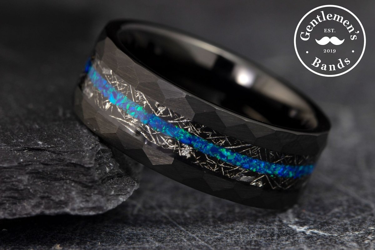 The Atlas, a black tungsten ring with a hammered and brushed finish features a meteorite and blue opal inlay.