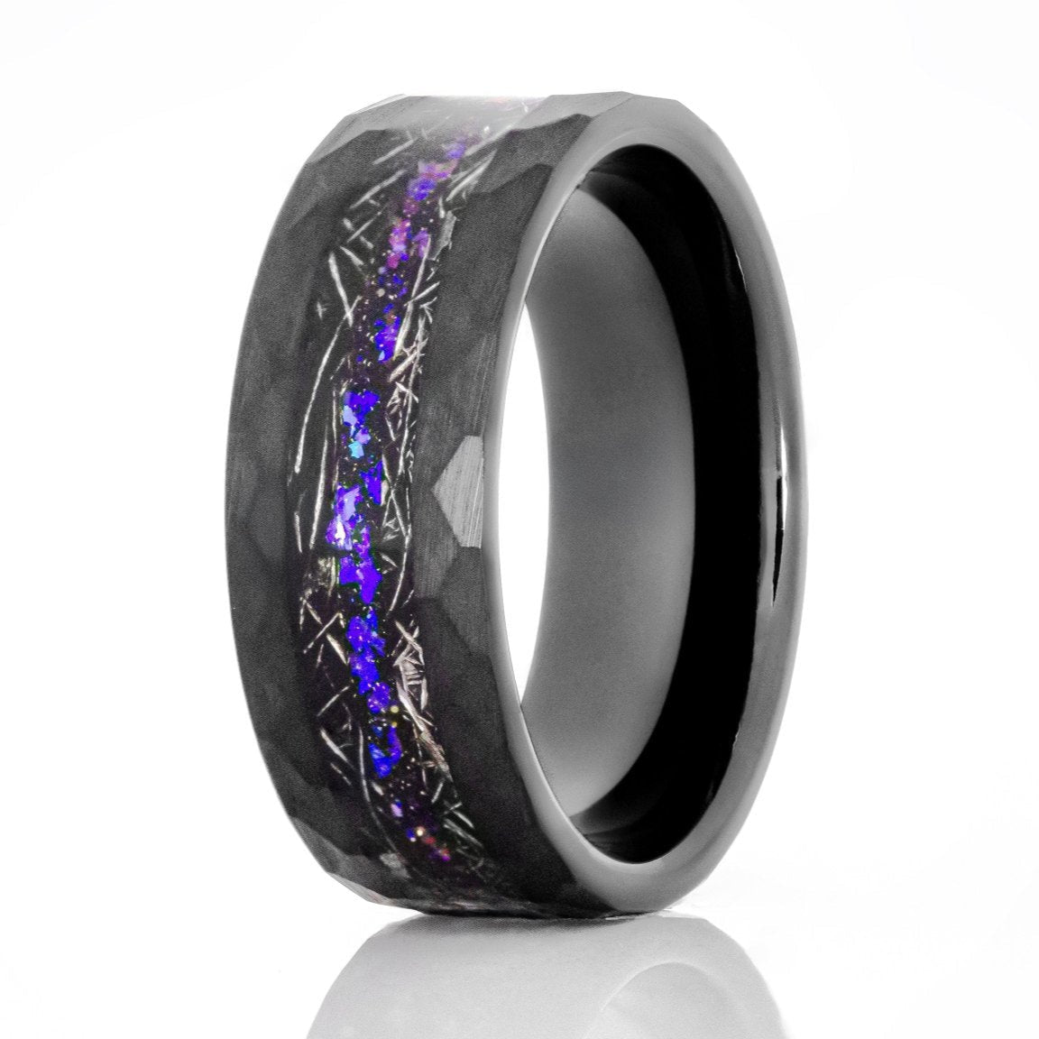 The Juno, a black tungsten carbide ring with a hammered and brushed finish that features a meteorite and galaxy opal inlay.