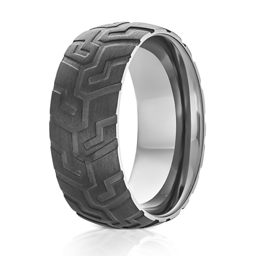 The Mechanic, a black tungsten ring that features a black carved tire tread and silver polished band.