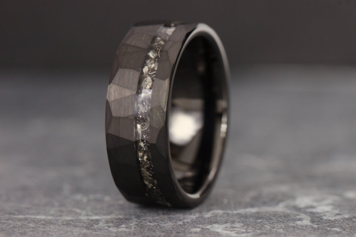 The Astronomer, a black tungsten ring that features a hammered and brushed finish and a meteorite inlay.