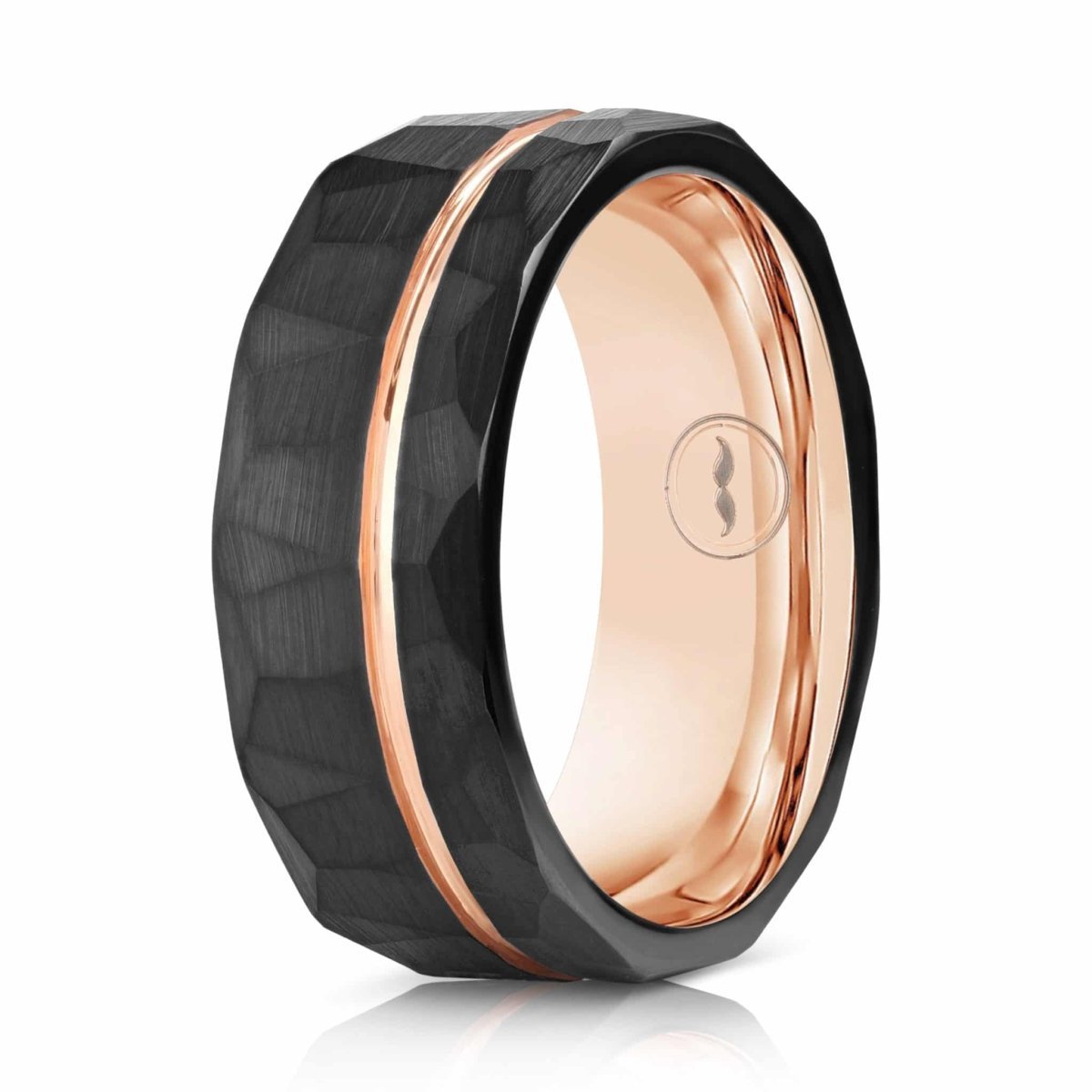 The Rambler, a black tungsten ring that features a hammered and brushed finish and a rose gold groove and band.